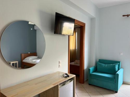 a room with a mirror and a blue chair at Hotel Prinos in Himare