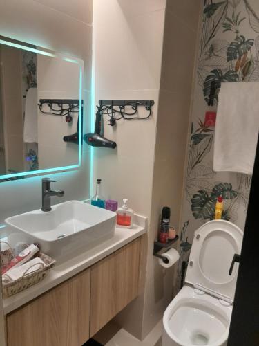 a bathroom with a sink and a toilet and a mirror at Acquila Crest by JKIA in Nairobi