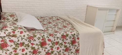 a bedroom with a bed with a floral comforter at Casa condomínio clube in Araruama