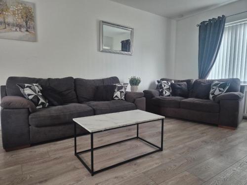 a living room with a couch and a coffee table at 3 bedroom house-Ellesmere Port in Ellesmere Port