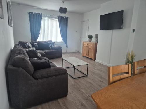 a living room with a couch and a table at 3 bedroom house-Ellesmere Port in Ellesmere Port
