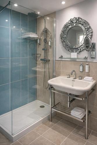a bathroom with a shower and a sink and a mirror at Vanbrugh House Hotel in Oxford