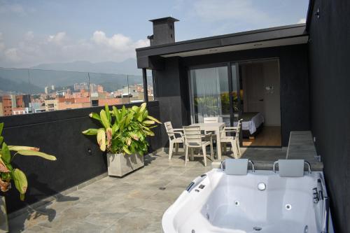 a bath tub on the balcony of a house at Hotel Ryo 74B Suites by Growing Group in Medellín