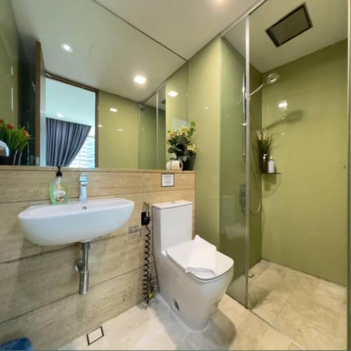 a bathroom with a toilet and a sink and a shower at Vortex Apartment klcc by HouseFull in Kuala Lumpur