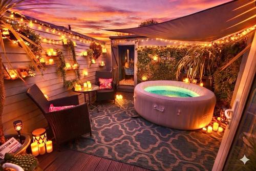 a jacuzzi tub on a patio with lights at A Hidden Gem With Private Hot Tub and Garden - Netflix - Fast Wifi - Free Parking in Bournemouth