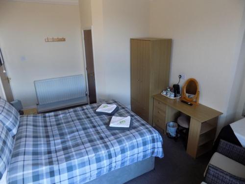 una stanza d'albergo con un letto, una scrivania e un letto sidx sidx sidx di Belle View a Skegness