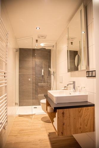 a bathroom with a sink and a toilet and a shower at Seehotel Schlick in Fuschl am See
