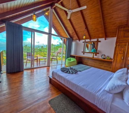 a bedroom with a bed and a large window at Mount Hunt Resort Beragala Haputale in Beragala