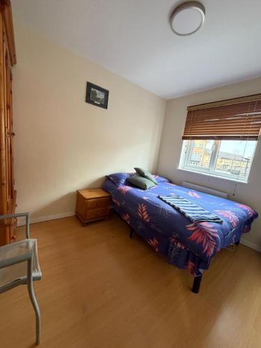 a bedroom with a bed with a blue comforter and a window at Beautiful Double Room in Heart of London in London