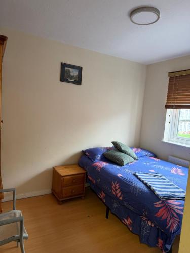 a bedroom with a bed with a blue comforter at Beautiful Double Room in Heart of London in London