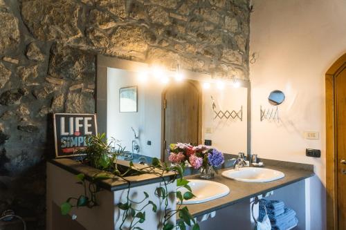 a bathroom with two sinks and a stone wall at CollinaBlu in Torre San Severo
