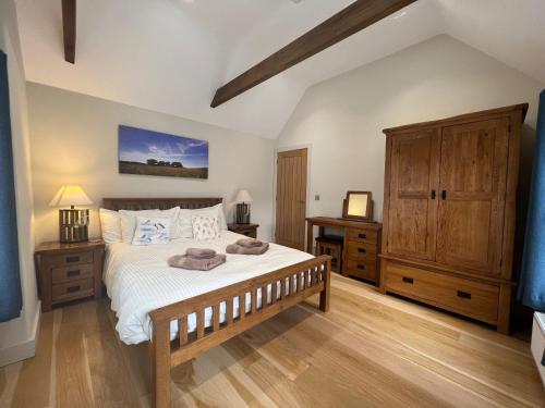 a bedroom with a large bed and wooden floors at Heron's Hideaway in Wells next the Sea