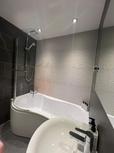 a bathroom with a tub and a sink and a shower at Heron's Hideaway in Wells next the Sea
