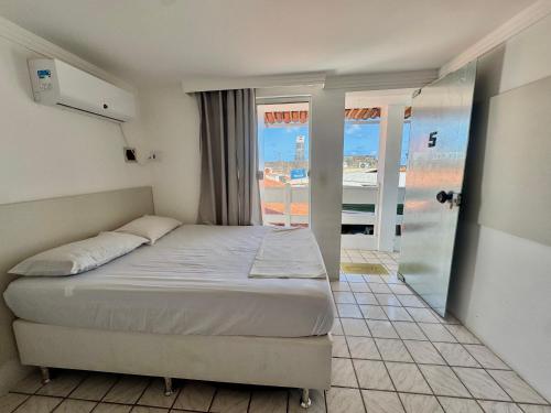 a bedroom with a bed and a view of the ocean at Pousada e Hostel Natal in Natal