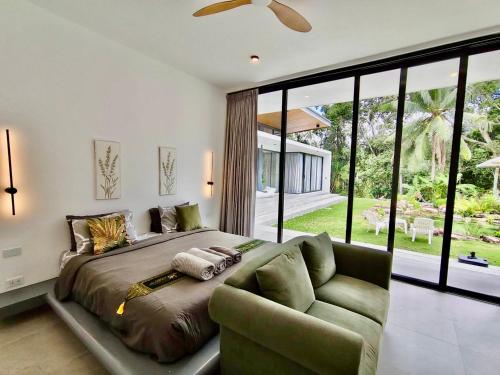 a bedroom with a large bed and a couch at Villa harmony haven in Taling Ngam in Ban Khok Kroat