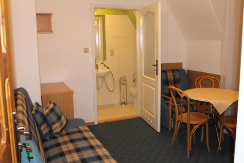 a room with a table and a bathroom with a sink at Nasz Dom in Kościelisko