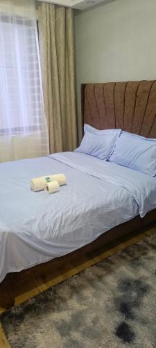 a bed with two towels on top of it at Hillary homes in Nairobi