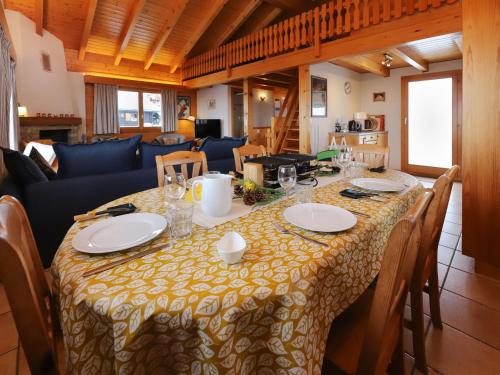 a dining room table with a yellow and white table cloth at Chalet Lara by Interhome in Nendaz