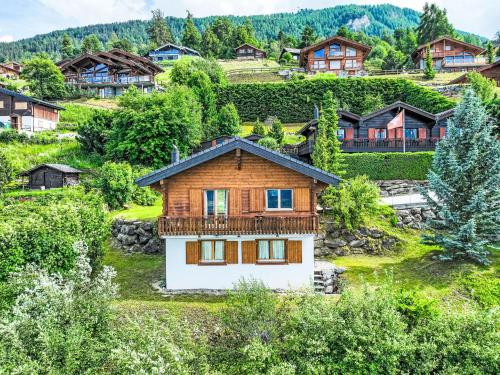 a wooden house on a hill with houses at Chalet Lara by Interhome in Nendaz