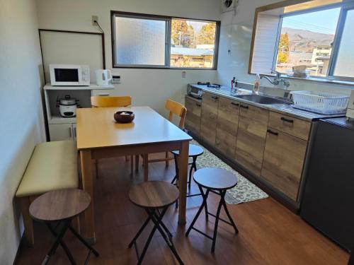 a kitchen with a table and some stools in it at 8 minutes by walk to Nikko Station Mitsuba House in Nikko