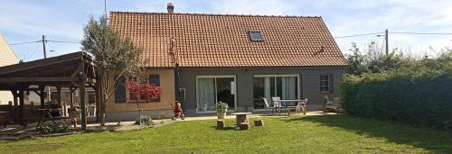 a small house with a yard with a patio at Gîte spacieux, Proche Plage, Grand jardin in Neufchâtel-Hardelot