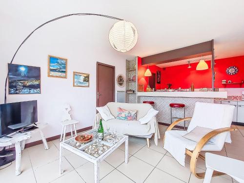a living room with white furniture and a red kitchen at Holiday Home Gevanac by Interhome in Crozon
