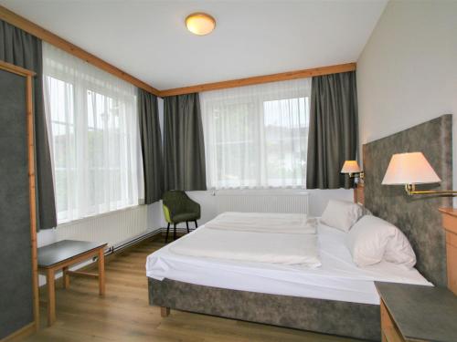 a hotel room with a bed and a chair at Apartment Lechners Wohnwelt-2 by Interhome in Stumm