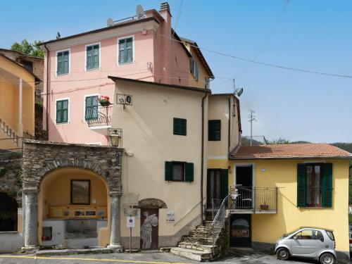 a pink and yellow building with a car parked in front at Holiday Home Ca' da Ciassa - Prima Porta - VLO132 by Interhome in Pantasina