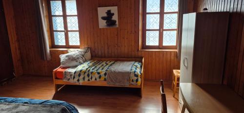 a bedroom with a bed in a room with windows at gite climatisé jusqu'à 9 personnes secteurs la broque Obernai Strasbourg in La Broque