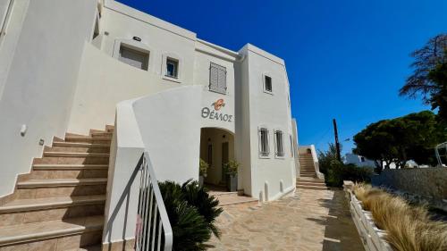 a white building with stairs leading up to it at Thealos in Azolimnos Syros