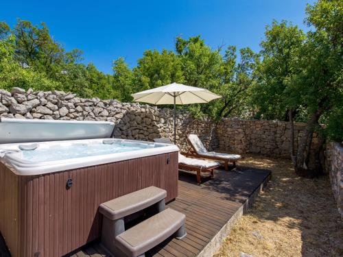 a hot tub on a wooden deck with an umbrella at Holiday Home Tomiceva by Interhome in Gornja Klada