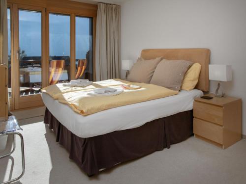 a large bed in a room with a window at Apartment Bella Vista Apt- No- 09 by Interhome in Wengen