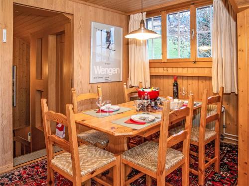 a dining room with a wooden table and chairs at Apartment Plein Soleil by Interhome in Wengen