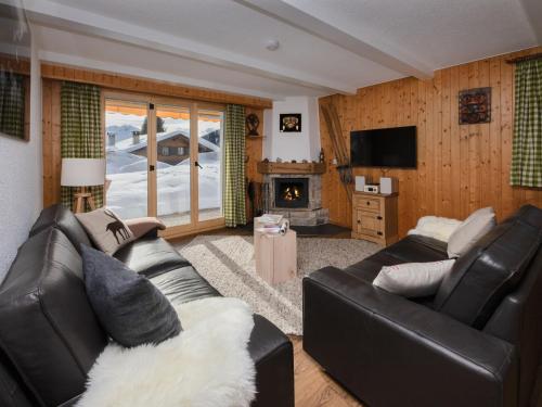 a living room with two leather couches and a fireplace at Apartment Baroudeur B04 by Interhome in Verbier