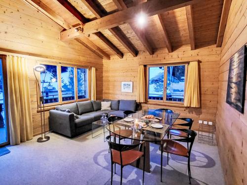 a living room with a table and a couch at Apartment Chalet mit Bergsicht by Interhome in Laax