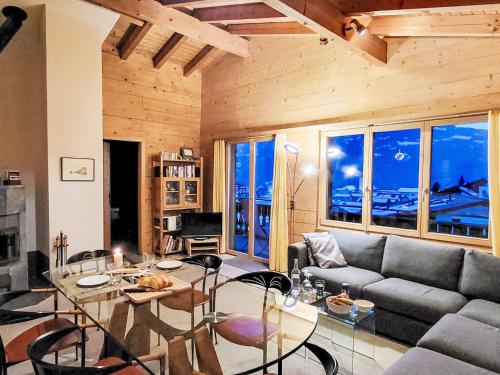 a living room with a couch and a table at Apartment Chalet mit Bergsicht by Interhome in Laax