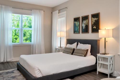 a bedroom with a large bed with two windows at Just Beach Baby! by Pristine Property Vacation Rentals in Cape San Blas