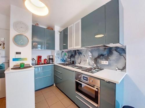 a kitchen with blue cabinets and a stove top oven at Apartment la Pergola-2 by Interhome in Soorts-Hossegor