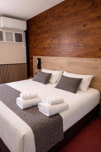 a bedroom with a large bed with towels on it at Logis Hotel Le Lac in Embrun