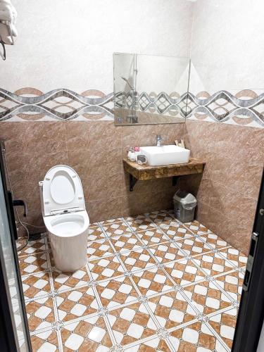 a bathroom with a toilet and a sink at Cao Ánh Hotel in Minh Hóa