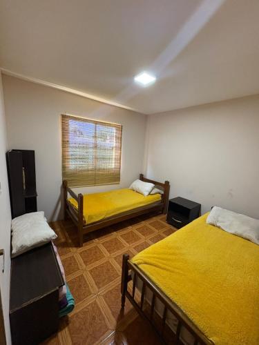 a room with two beds and a window in it at El Colibrí 1 in Arroyo Seco