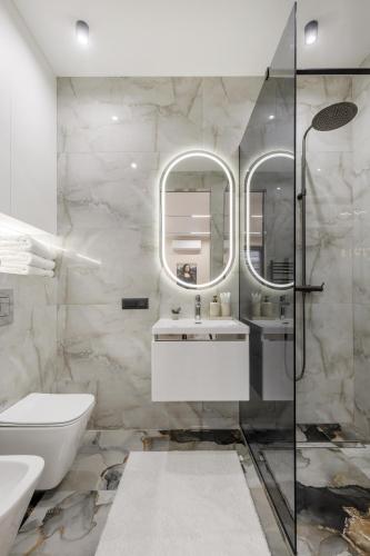 a bathroom with a sink and a toilet and mirrors at Renest Florence Art Escape in Chişinău