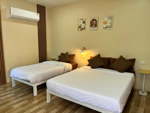 a room with two beds in a room at Sukhothai Indy Resort in Sukhothai