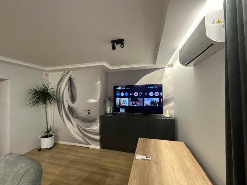 a living room with a table and a flat screen tv at Apartament rodzinny in Łańcut