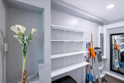 a room with white shelves and a vase with flowers at Stylish and Pet-Friendly Apartment in Beacon in Beacon