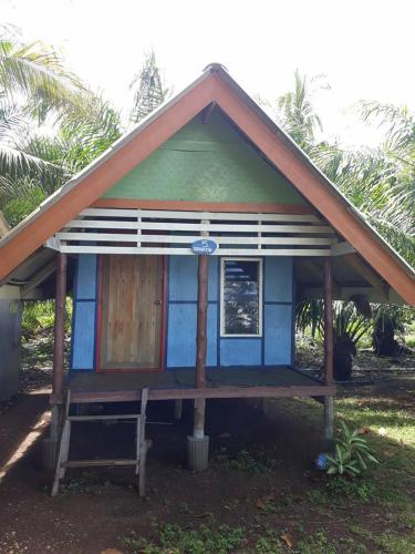 a small blue and green house with a porch at บากันใหญ่โฮมสเตย์ in Ban Ba Kan Yai