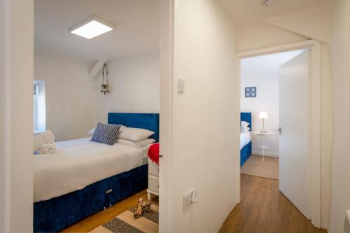 a bedroom with a bed and a door leading into a room at Ty Capel Bach in Bodorgan