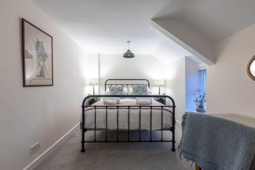 a bedroom with a bed in a white room at Kite Cottage in Llangadwaladr