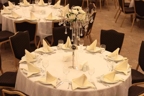 a table with white plates and napkins on it at Grand Hotel Gaziantep in Gaziantep