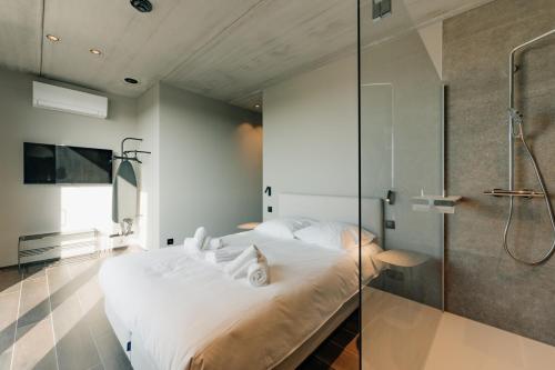a bedroom with a bed and a glass shower at Coliving - Bord de Meuse - L'écrin Vert in Oupeye